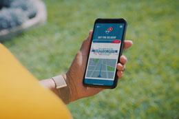 Person holding mobile phone with dominos app