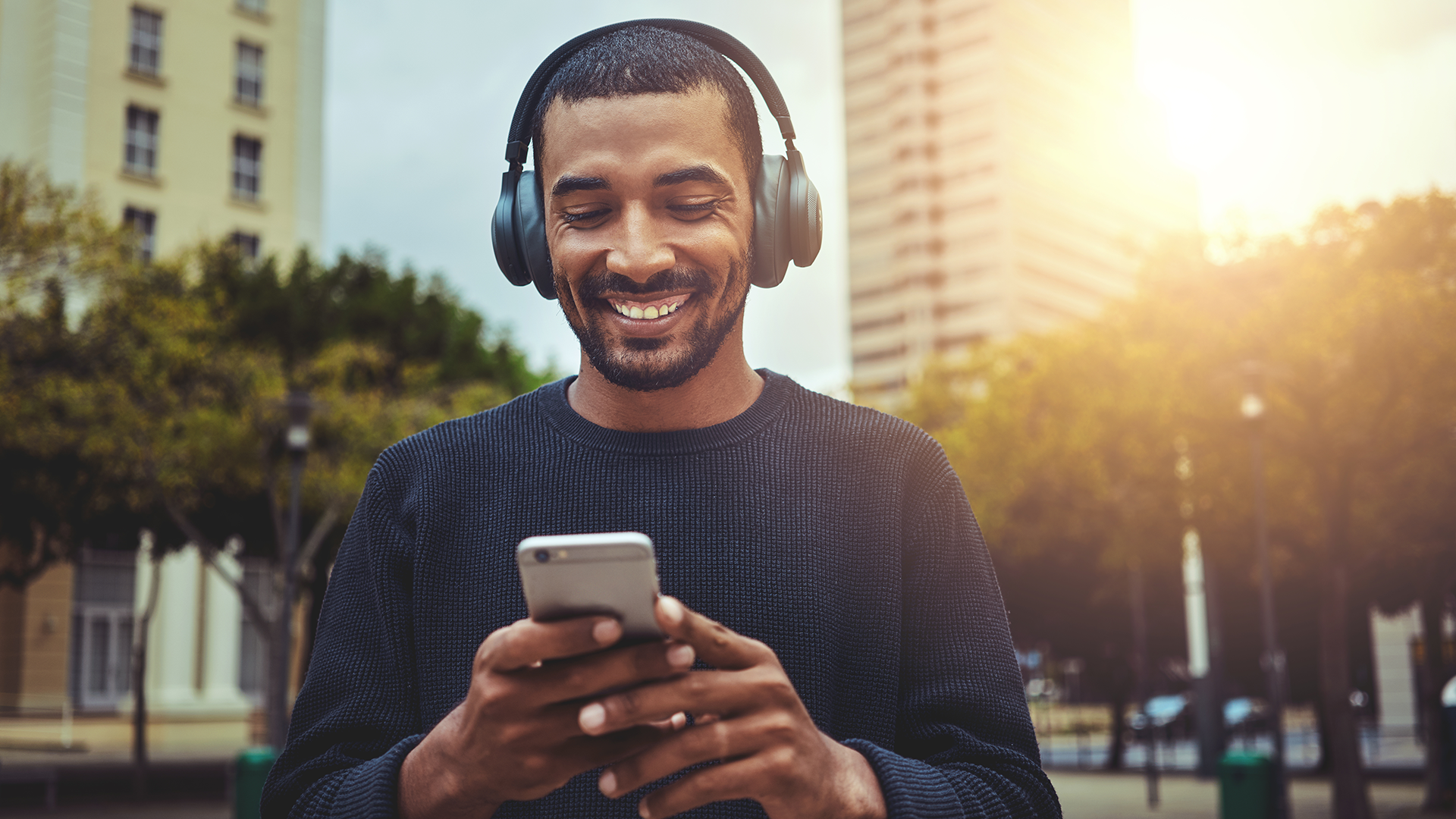 man with headphones looking at his phone