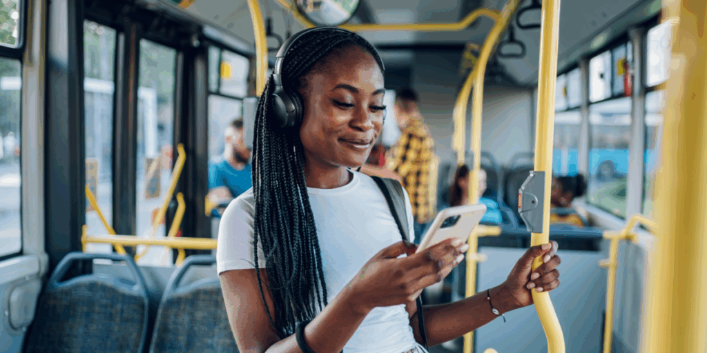 Woman on bus smiling at phone