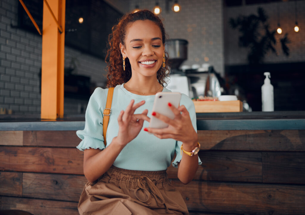 Woman in restaurant smiling at her social media account