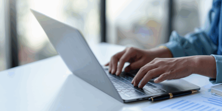 Person typing on a laptop, creating the perfect social media proposal