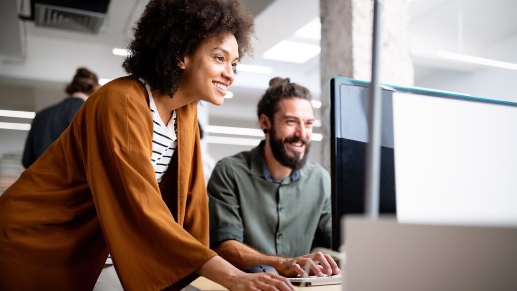 Team members looking at laptop, checking their customer feedback