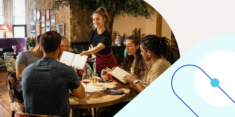 Server handing menus to a group of friends at a round table in a restaurant